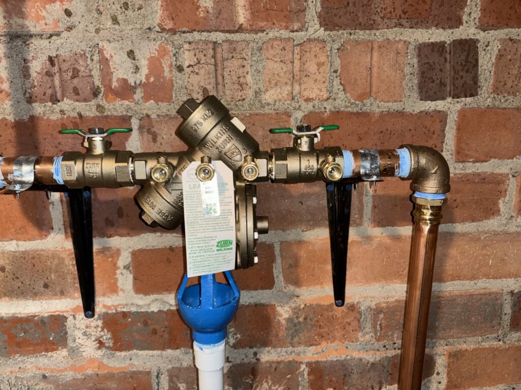 Zurn Wilkins backflow preventer repair with test ports and relief discharge.