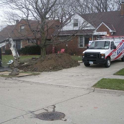A picture of a worksite with an Edwards Plumbing Heating and Cooling truck in the drive way