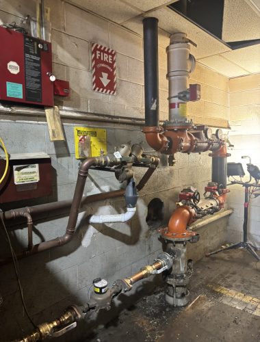 Commercial mechanical room with domestic and fire-protection backflow preventers inspected and tested by Edwards in Northeast Ohio