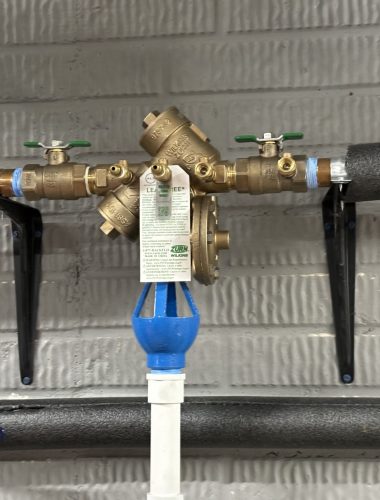 Zurn Wilkins reduced pressure zone backflow preventer with test ports and relief discharge.
